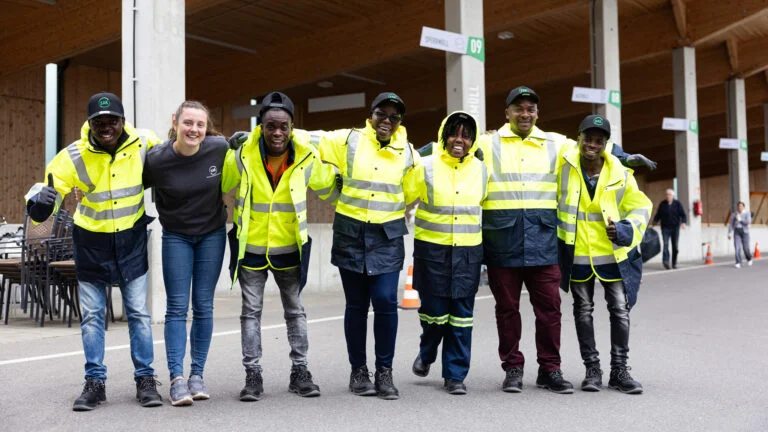 Menschen stehen mit Warnwesten im Kreis