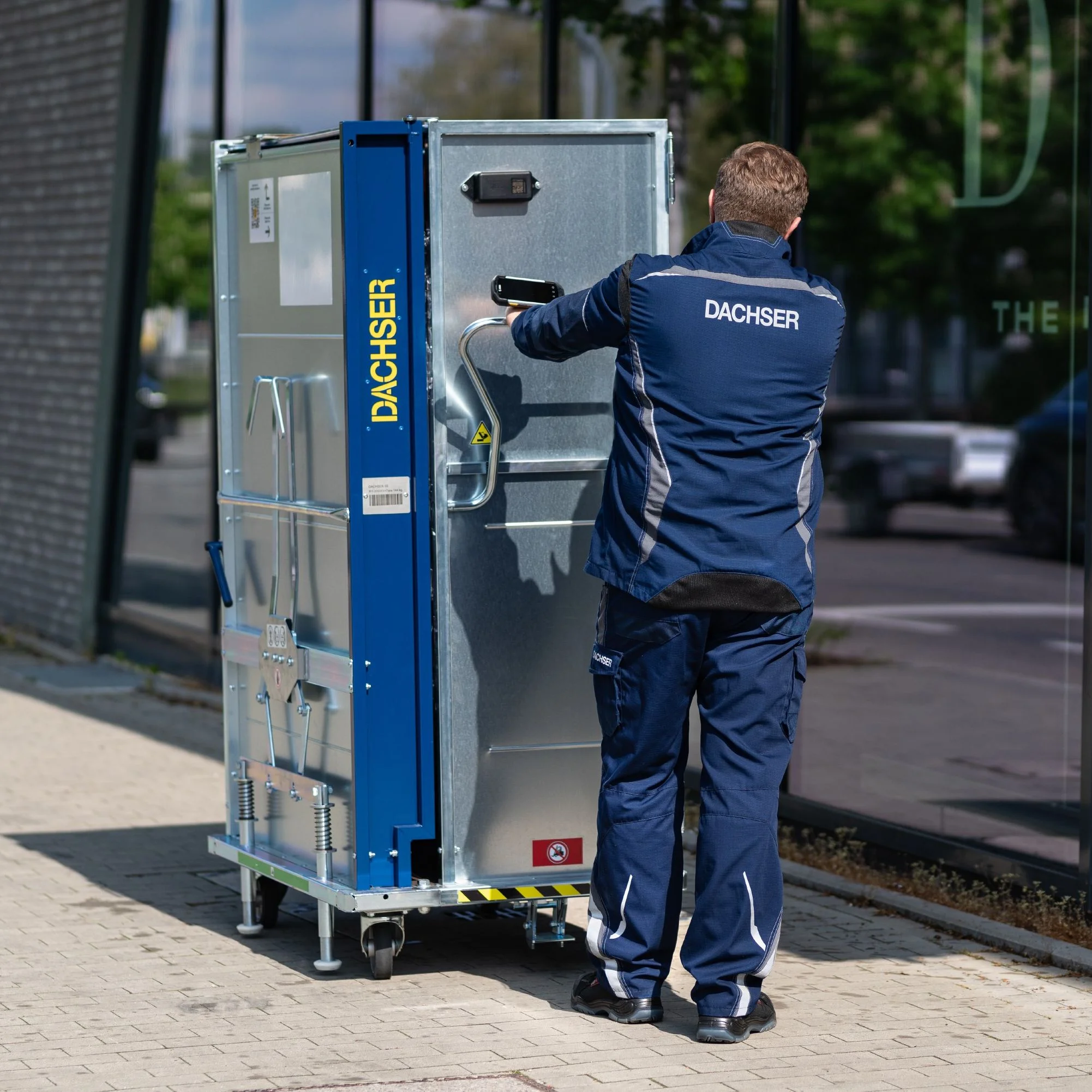 Dachser Mitarbeiter verschiebt kleines Transportbehältnis, die Retail Box