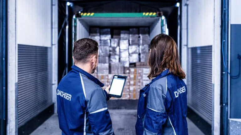 DGI_006348_1920_1080 DACHSER Mitarbeitende stehen mit einem Tablet vor dem offenen Laderaum einer Wechselbrücke