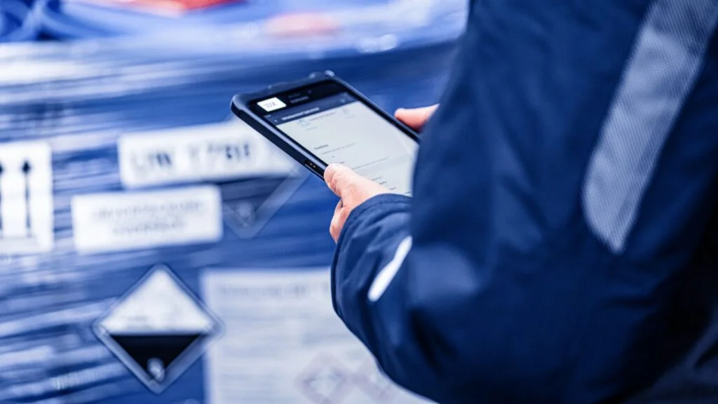 Ein Mitarbeitender hält ein Tablet in der Hand.