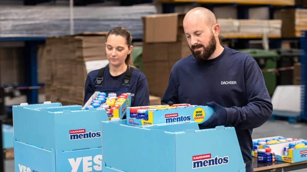 DGI_004456-JPG 2048 px Zwei DACHSER Mitarbeitende sortieren für den Kunden CFP Mentos Verpackungen in Displays ein.