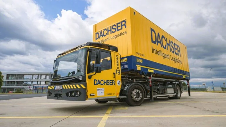 Ein elektrisch angetriebenes Wechselbrückenfahrzeug, auch Hochumsetzer genannt, steht auf dem Betriebshof der Niederlassung Erlensee, beladen mit einer Wechselbrücke mit DACHSER Aufschrift.